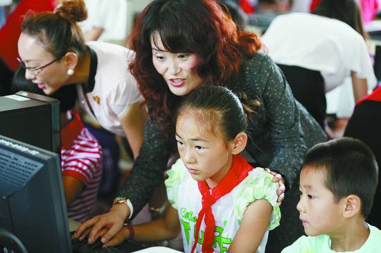 志愿者手把手指导孩子使用电脑