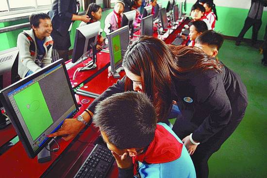 志愿者指导孩子用电脑制作贺卡