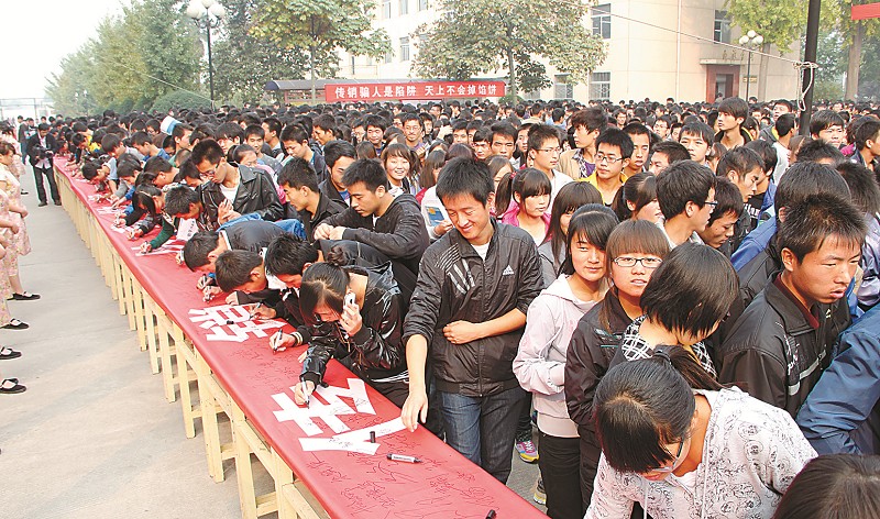 同学们在拒绝传销横幅上踊跃签字