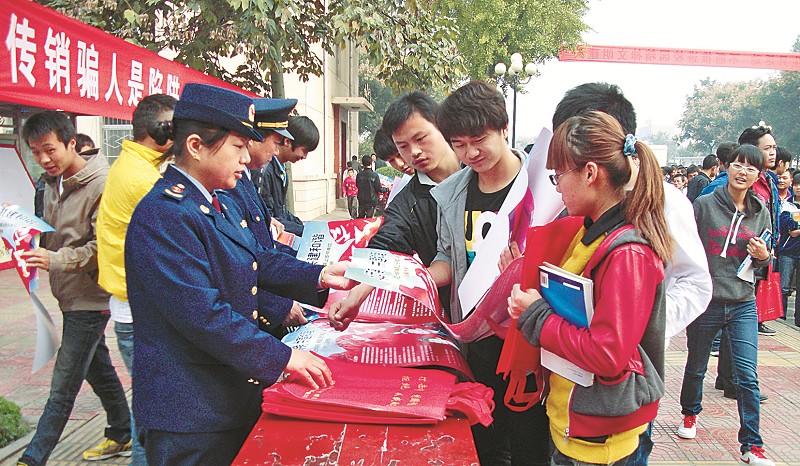 工商人员向学生发放打传宣传资料，引导他们远离传销
