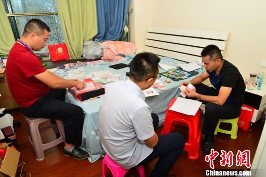 图为办案人员清查涉案物品 王勇 摄