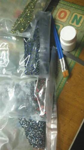 钻石画代加工者用于粘钻石画的胶水和颗粒，只能闲置在家中。 受访者供图