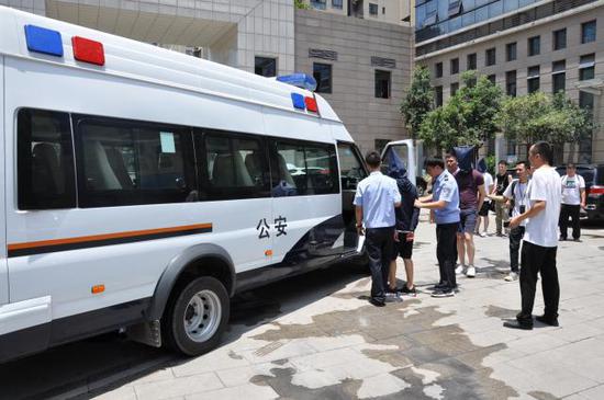 乐山警方押解嫌犯返回乐山。新京报记者 李玉坤/摄